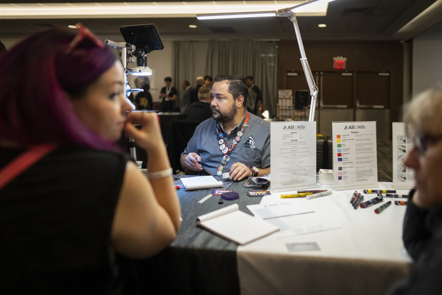 Attendees talking with an exhibitor across a pen display