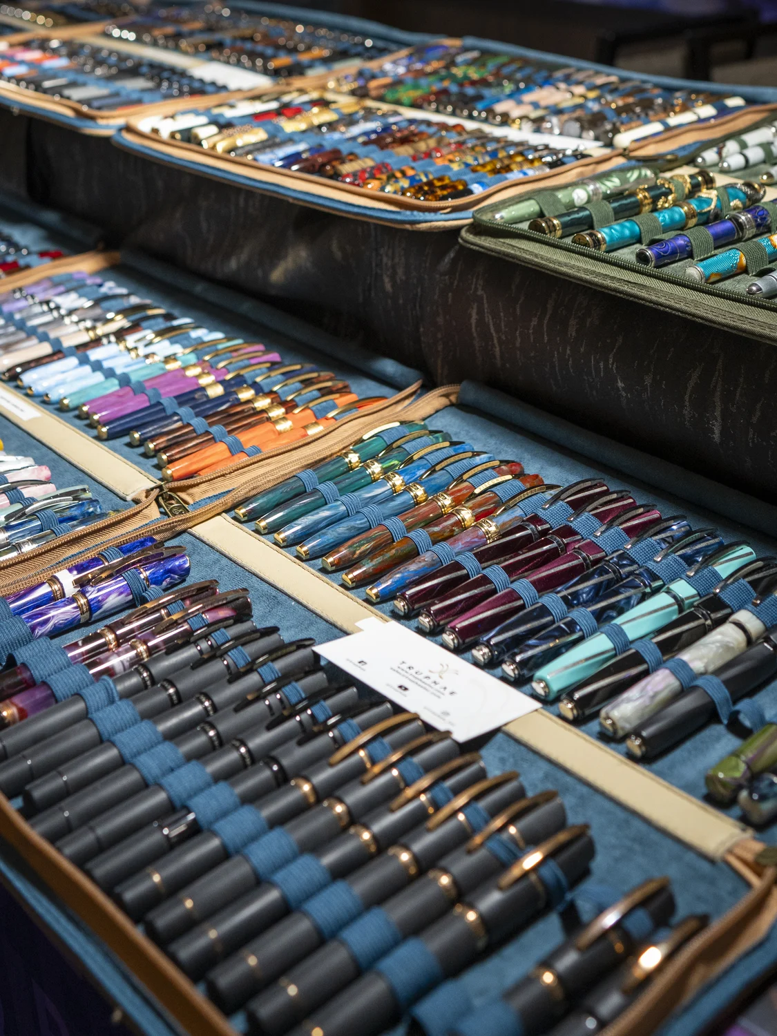 Trays of colorful fountain pens on an exhibitor table